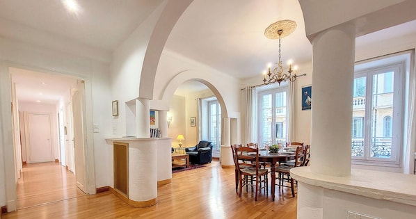 A spacious dining area with a high ceiling, a chandelier, and a view of the street through large windows. - N&J - MEYERBEER - Central - Very close sea (Niza)