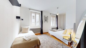 Una habitación de hotel moderna con cama, sofá, una mesita y un espejo.