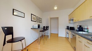Una cocina compacta con comedor, que incluye microondas, cafetera y lavavajillas.