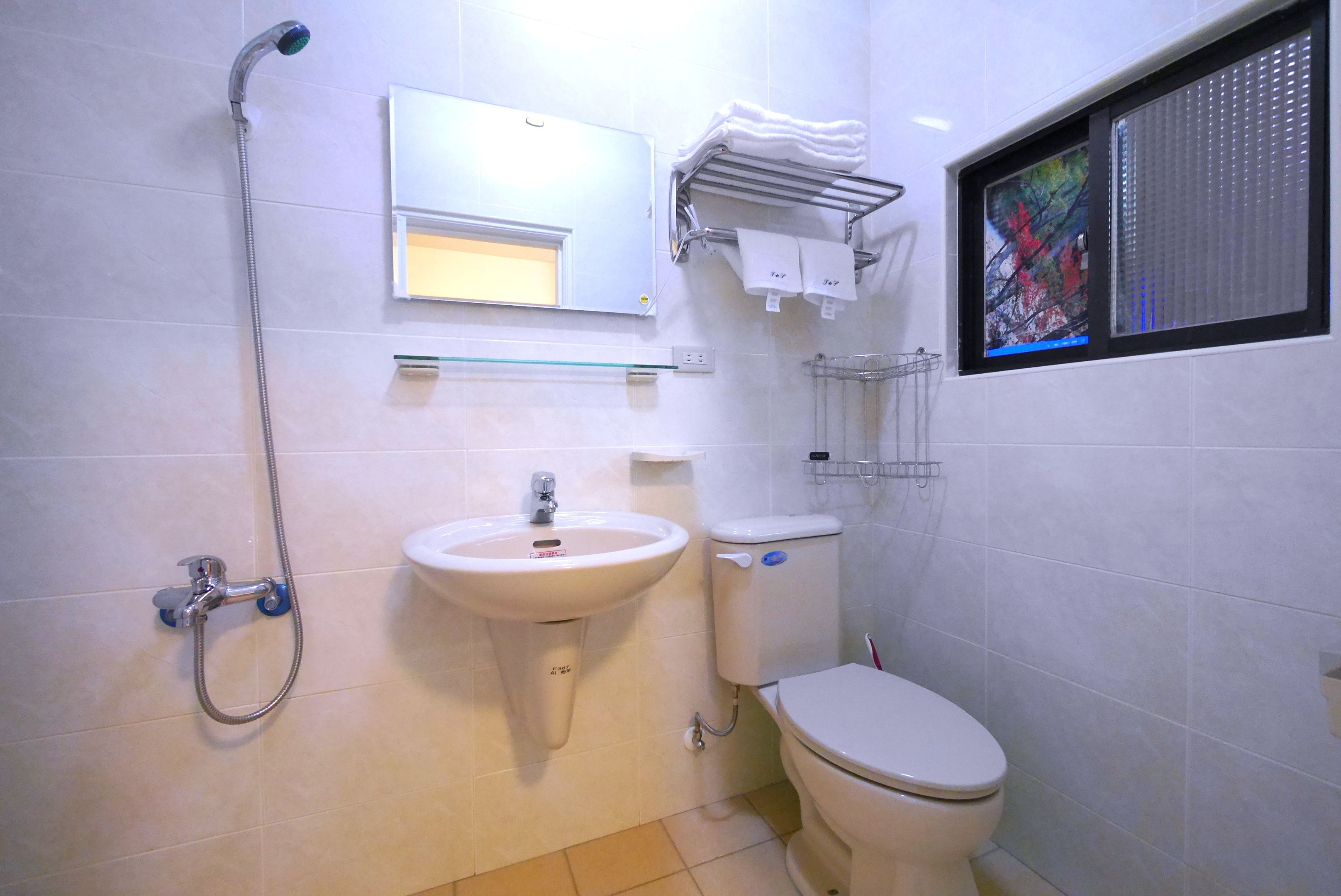Un baño con lavamanos, inodoro y ducha.