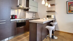 A modern kitchen with a central island, stainless steel appliances, and pendant lighting.