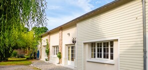 A building with a brick facade, white siding, and a panda logo. - Homerez - House near Montluçon (Montluçon)
