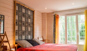 A bedroom with a bed, a wooden ladder, a chair, and a window with curtains. - Homerez - House near Montluçon (Montluçon)