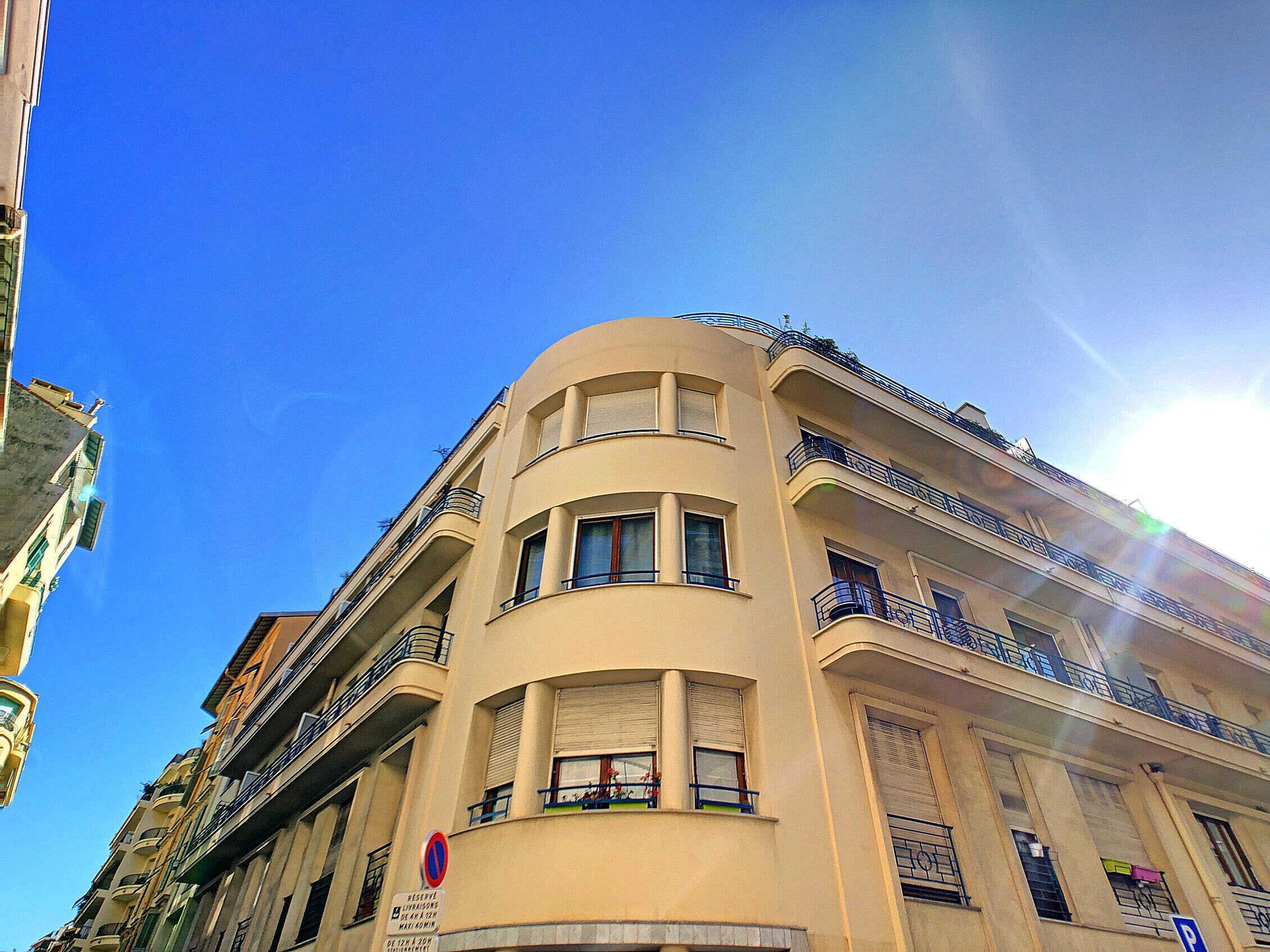 A multi-story building with balconies and a no parking sign.