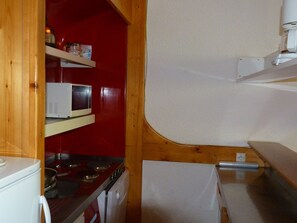 A compact kitchen with a microwave, stove, and a small refrigerator. - 4-bedroom duplex, ski-in/ski-out, near shops, balcony, 8-10 pers, Les Arcs 1800 (Les Arcs 1800)