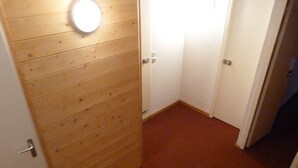 Puiset ovet, joissa on valaisin, valkoiset ovet, joissa on kahva, ja punaisella matolla peitetty lattia.