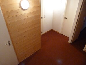 A wooden door with a light fixture, a white door with a handle, and a red carpeted floor. - 4-bedroom duplex, ski-in/ski-out, near shops, balcony, 8-10 pers, Les Arcs 1800 (Les Arcs 1800)
