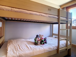 A bunk bed room with a white mattress and a wooden headboard. There are toys on the bed. - Renovated apartment for 8, ski-in/ski-out with parking (Les Menuires)