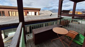 A wooden deck with a table and chairs, overlooking a mountainous landscape. - 2-room apt for 5 in Villards, Arc 1800, pets allowed (Les Arcs 1800)