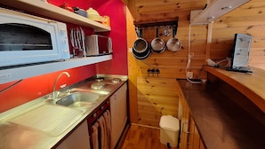A compact kitchen with a red accent wall, a built-in oven, a sink, and a small trash bin. - 2-room apt for 5 in Villards, Arc 1800, pets allowed (Les Arcs 1800)