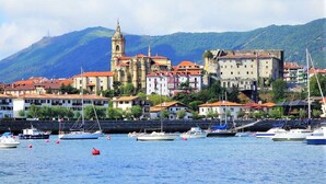 Una cittadina costiera con edifici storici, una chiesa importante e una struttura simile a un castello.
