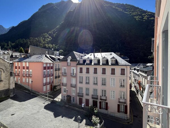A street view with buildings, a clear sky, and a mountain in the background.