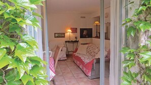 A cozy living room with a sofa, a table with a red and white checkered tablecloth, and a lamp. - Homerez - House in Saint Branchs (Saint Branchs)