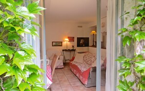 Une pièce confortable avec un lit, une table sur laquelle se trouve une lampe, et un tableau accroché au mur.