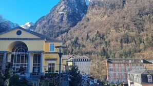A building with a large arched window and a sign reading "CESAR". - 2-Room Apartment 4 Pers | Center Cauterets (Cauterets)