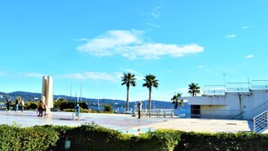 A public square with a modern building, palm trees, and a clear blue sky. - Modern Apartment, 2 Bedrooms, Terrace, A/C, Parking, Near Beach, Cavalaire (Cavalaire-sur-Mer)
