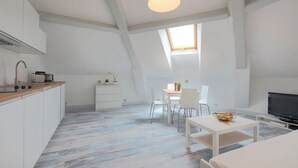 Um quarto moderno e bem iluminado, com cozinha, sala de jantar e área de estar.