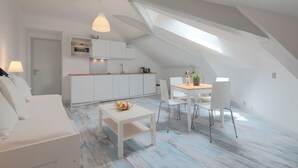Um apartamento tipo loft moderno, com área de jantar, cozinha e um espaço de estar aconchegante.