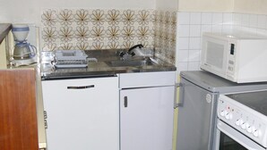 A compact kitchen with a sink, microwave, and a small refrigerator. - Charming Ski-In Apartment, Sleeps 6, South-Facing Balcony, Ideal for Families - Peyragudes (Gouaux-de-Larboust-Les Agudes)