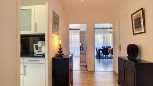 A hallway with a kitchen on the left, a dining area in the center, and a living room on the right. - N&J - L'OLYMPIC - Central - Very close sea (Niza)
