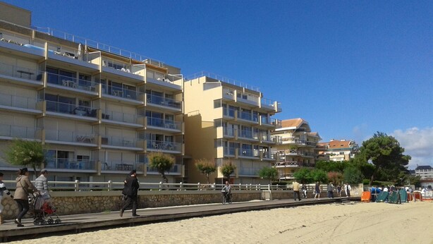 A beachfront hotel with multiple balconies, a sandy beach, and a clear blue sky. - Charming 1-Bed Apt with South-Facing Terrace, Beach Access & Parking in Arcachon (Arcachon)