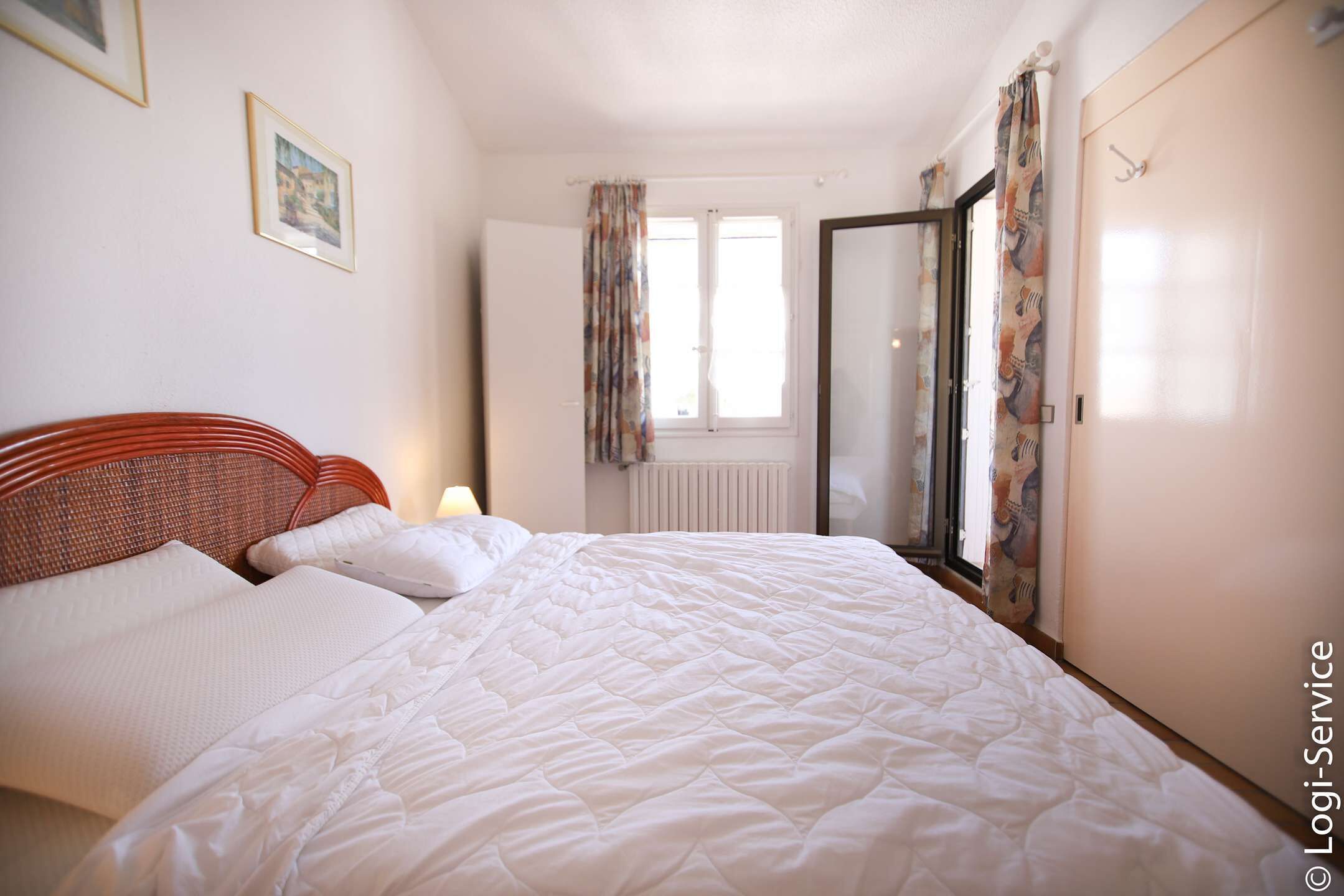 Un dormitorio con cama, ventana y puerta.