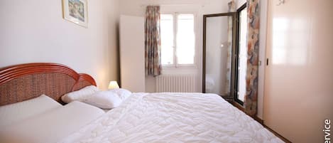 Un dormitorio con cama, ventana y puerta.