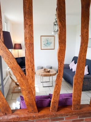 Un salon avec une table basse ronde, un canapé et une lampe.