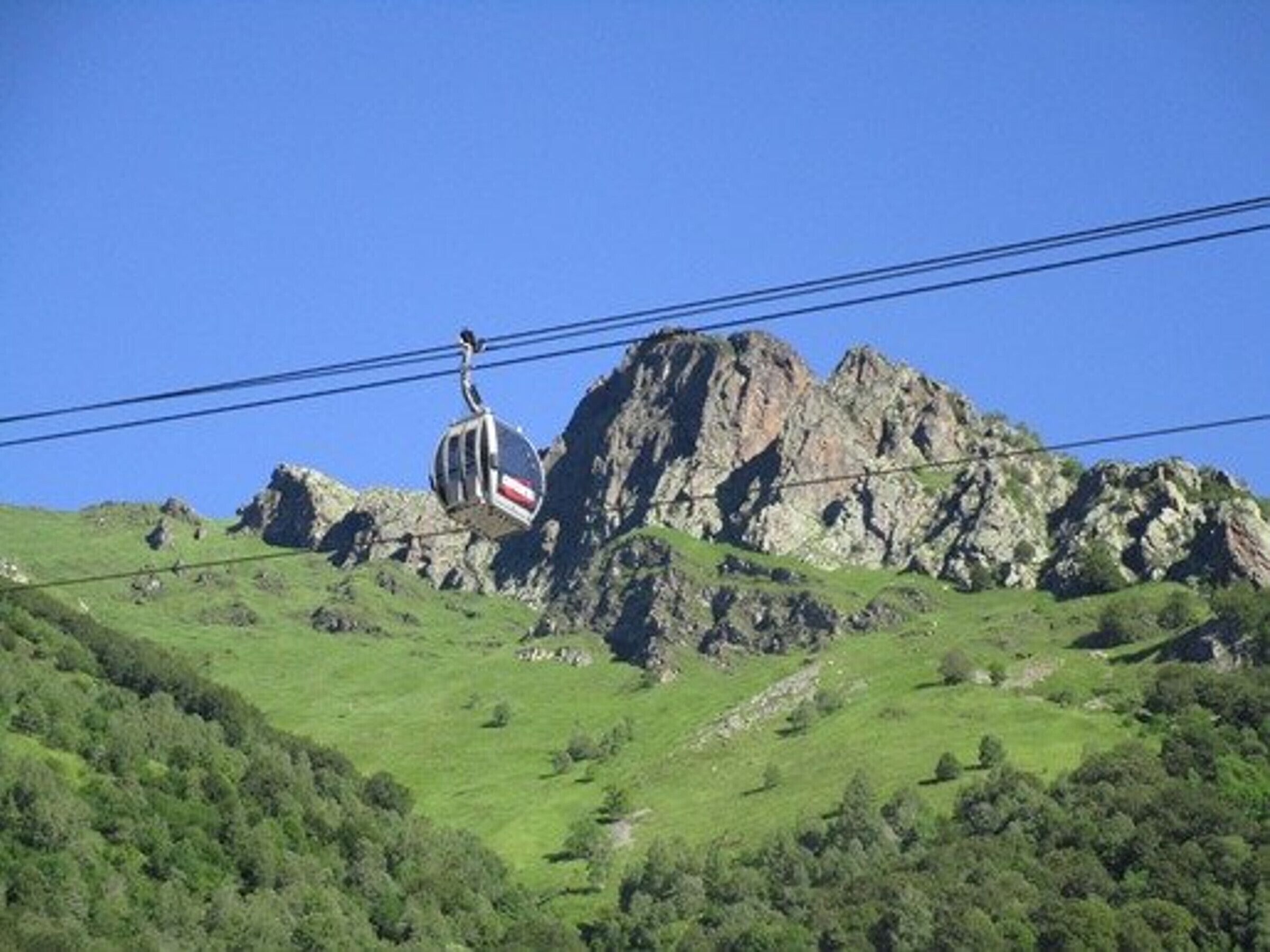 Un téléphérique avec un paysage montagneux en arrière-plan.