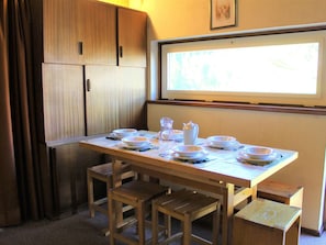A wooden dining table with benches, set with plates, bowls, and a pitcher. - Cozy 2-Room Mountain Apartment for 5 in the Heart of Vars, Near Slopes and Shops (Vars)