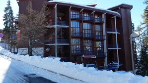 A multi-story hotel with balconies, a ski lift in the background, and snow on the ground. - Renovated duplex, pets allowed, for 5 near slopes and shops (Les Arcs 1800)
