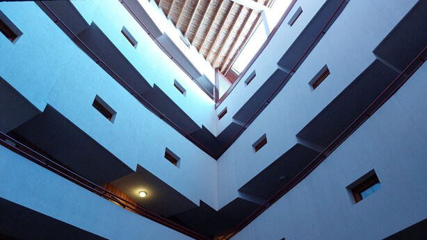 A multi-level atrium with a central open space and balconies on each floor. - Renovated duplex, pets allowed, for 5 near slopes and shops (Les Arcs 1800)