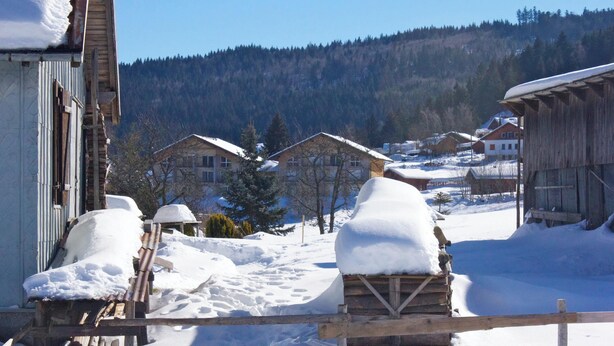A snowy village with wooden buildings and a clear sky.