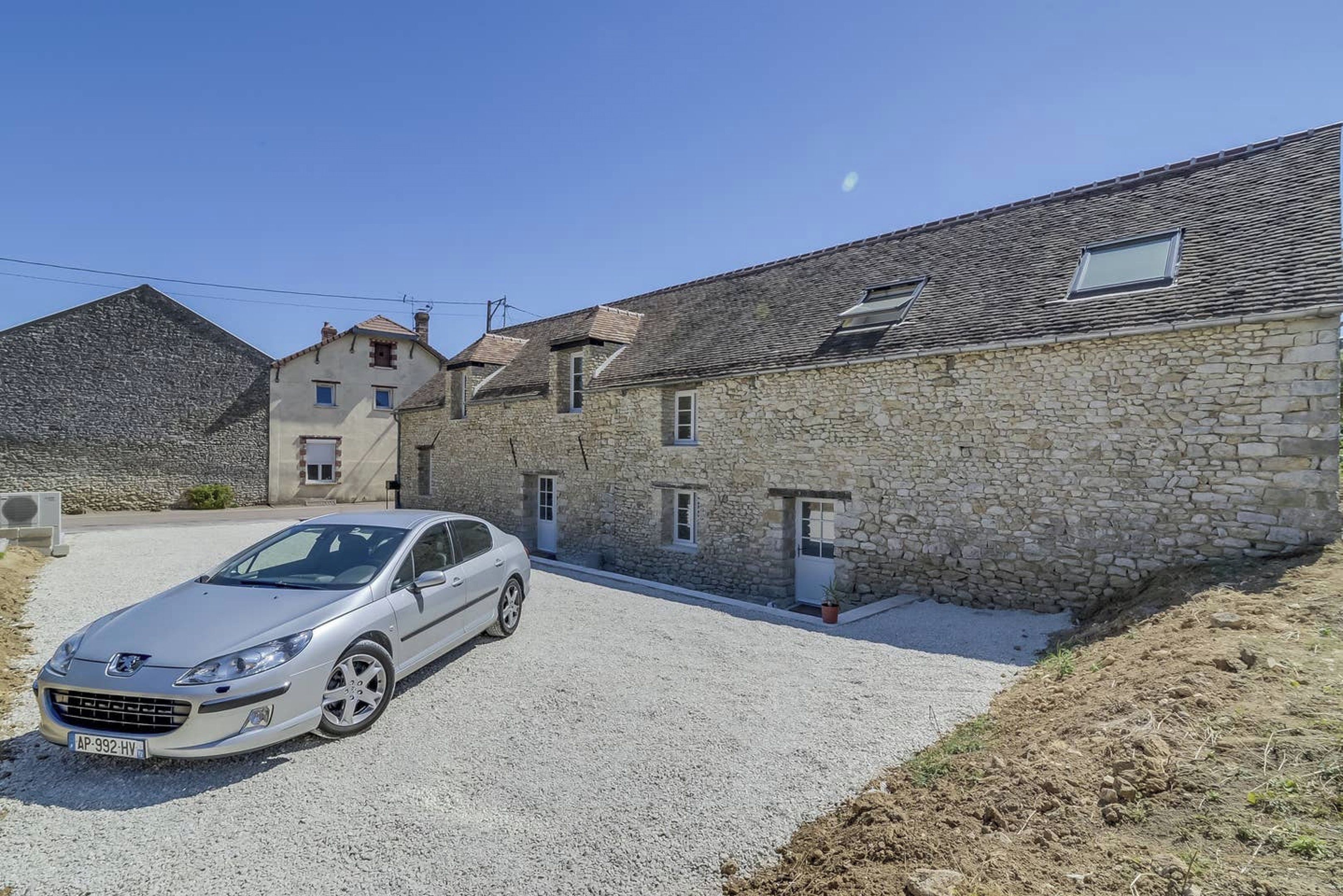 Un bâtiment en pierre avec une voiture garée devant.