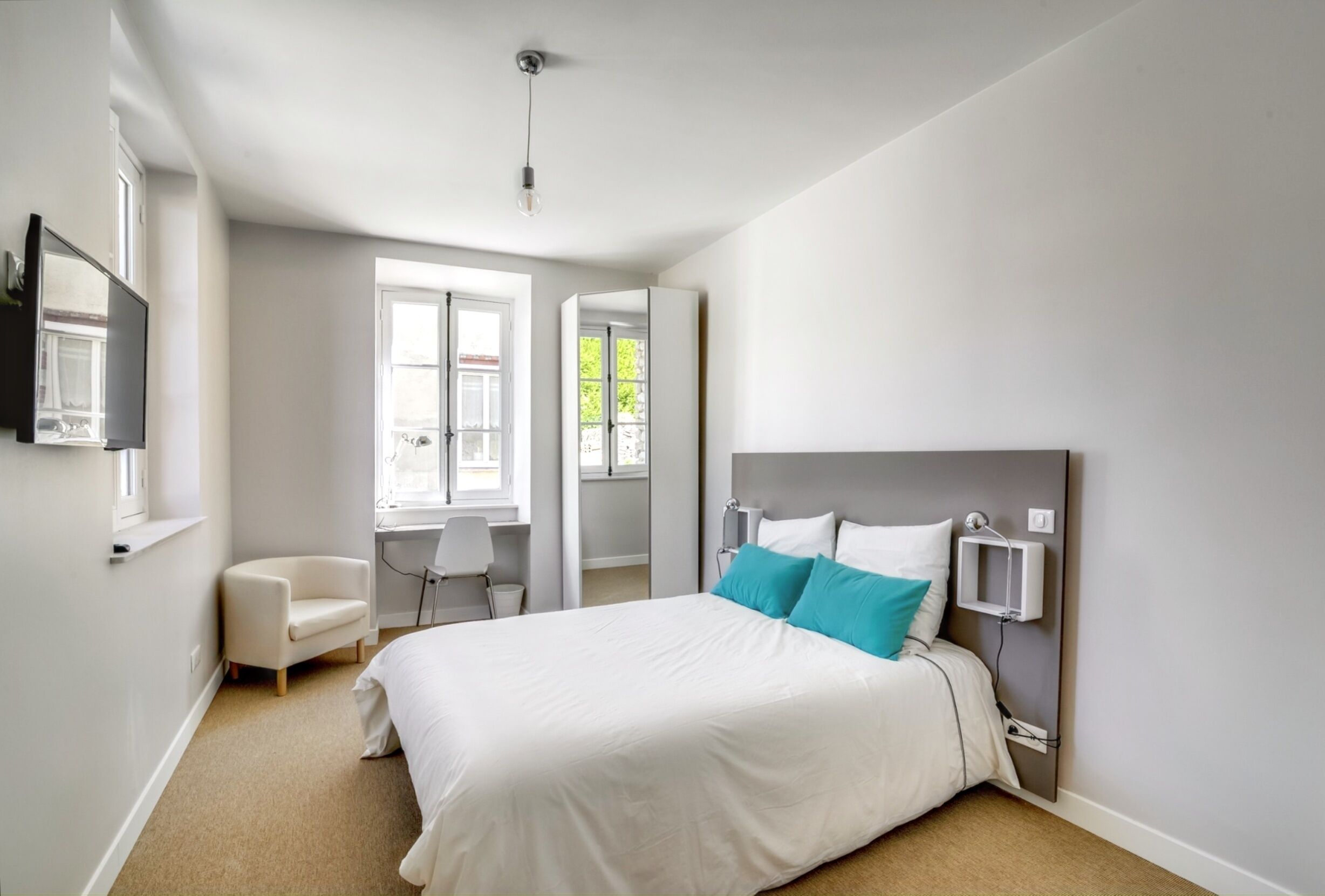 Une chambre à coucher moderne avec un grand lit, un bureau et une chaise.
