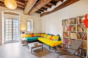 A cozy living room with a sectional sofa, a bookshelf, and a coffee table.