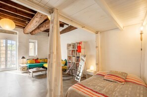 Ein Zimmer mit einem Bett, einem Bücherregal, einem Fenster und einer Tür.