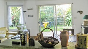 Une cuisine avec un coin repas, une grande fenêtre et une vue sur le jardin.