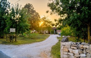 A gravel path leading to a building with a stone wall on one side.