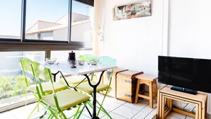 Un'area pranzo moderna con tavolo, sedie e televisione.