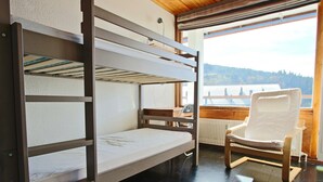 A bunk bed room with a view of a snowy landscape.