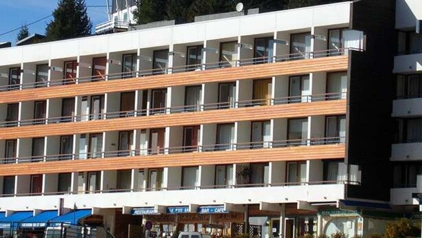 A multi-story hotel with balconies, a restaurant, and a bar.