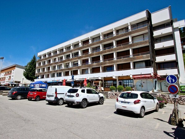 A multi-story hotel with a parking lot in front.