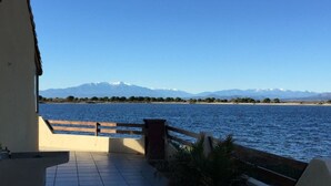 Una terraza con vistas a un lago y montañas.