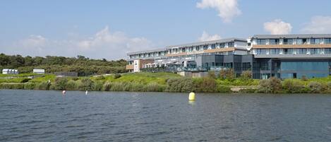A modern building with a sign reading "Relais Thalasso" by the water.