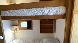 A bunk bed with a window and a shelf. - Cozy studio for 4 in Méribel Altiport, ski-in/ski-out (Méribel)