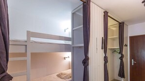 A bunk bed room with a wardrobe and a door. - Lovely studio for 6 people at the foot of the slopes (Gourette)