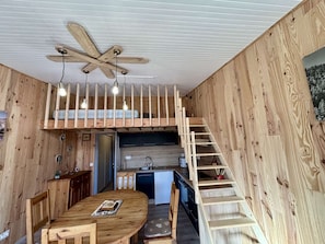 A compact, wooden interior with a loft bedroom, a dining area, and a kitchen. - Central Studio, Sleeps 4 - Near Slopes & Shops, South-Facing Balcony, Pet-Friendly (Huez)