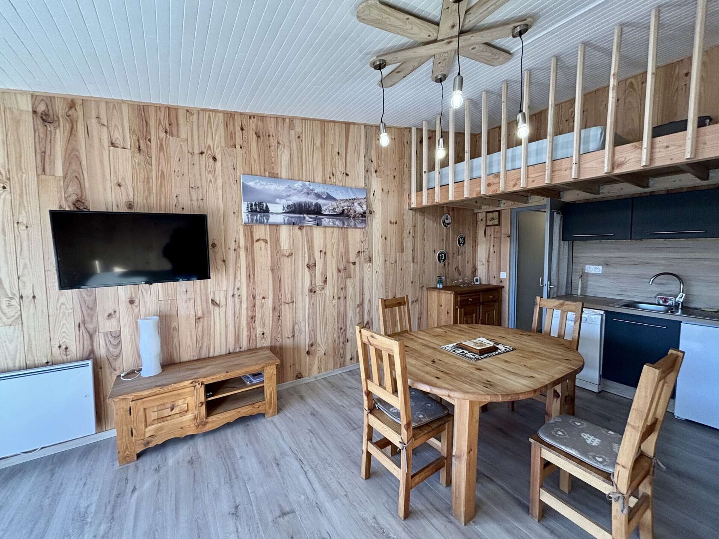 A modern kitchen with a built-in oven and a dining area with a wooden table and chairs.