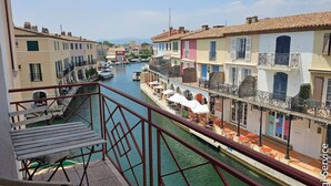 A canal view with buildings on either side, a bridge, and boats. - Renovated 1 bedroom flat for 2 persons (PORT GRIMAUD)